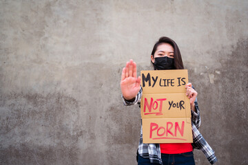 Ethnic female in protective mask standing with My Life Is Not Your Porn carton poster during protect against sexual harassment and assault