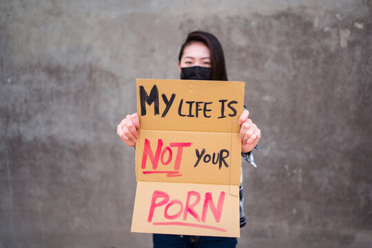 Ethnic female in protective mask standing with My Life Is Not Your Porn carton poster during protect against sexual harassment and assault