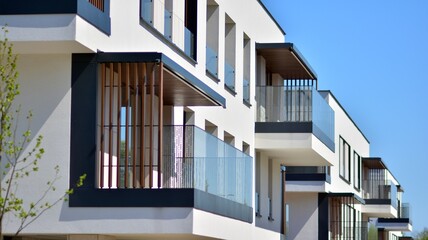 Obraz premium Condominium and apartment building with symmetrical modern architecture. Detail in modern residential flat apartment building exterior. Fragment of new luxury house and home complex. 