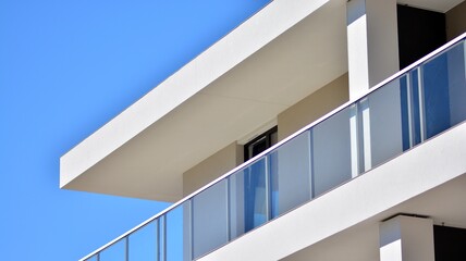 Fototapeta premium Condominium and apartment building with symmetrical modern architecture. Detail in modern residential flat apartment building exterior. Fragment of new luxury house and home complex. 