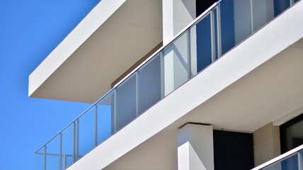 Obraz premium Condominium and apartment building with symmetrical modern architecture. Detail in modern residential flat apartment building exterior. Fragment of new luxury house and home complex. 