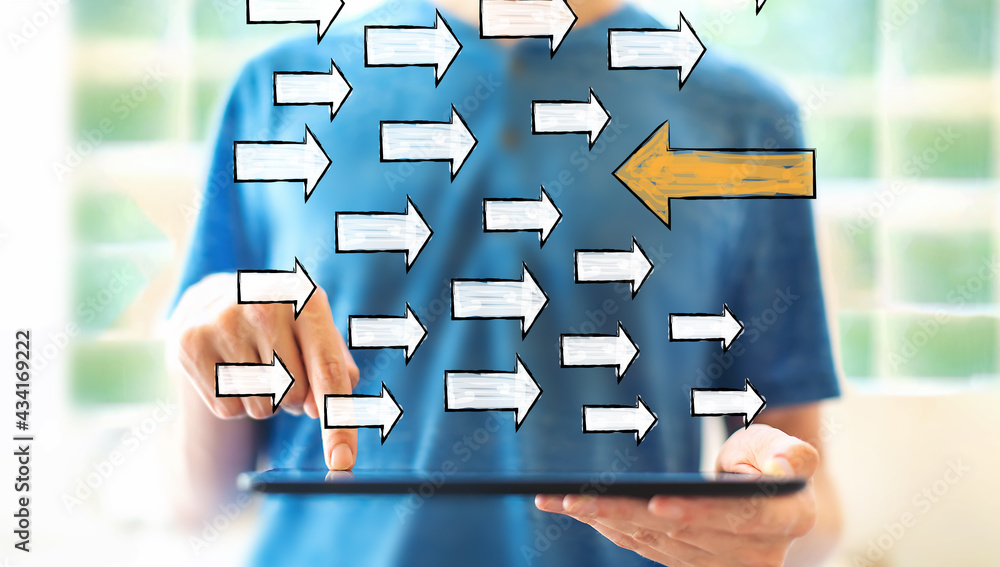 Poster arrow going in the opposite direction with man using a tablet