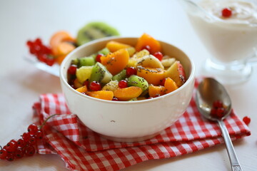 A bowl of fresh berry fruit salad on the white kitchen table. Vegan snack, diet food, healthy food concept. Healthy vegan snack or Breakfast. The concept of weight loss, healthy eating.