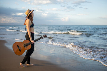 beautiful girl plays guitar in the beach