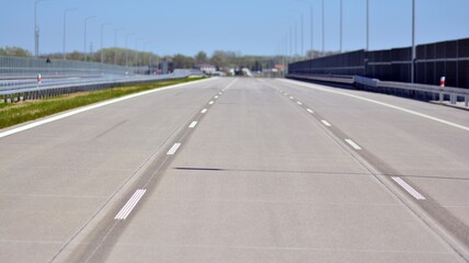 Straight modern concrete  motorway with bright road marking. Transportation road system infrastructure. 