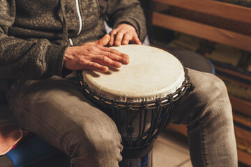 The drummer plays the ethnic percussion musical instrument djembe