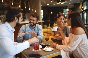 Group of young beautiful people hanging out in a cafe