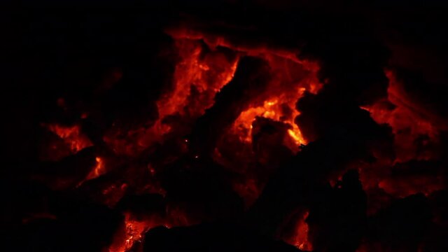 Rescoldos rojos y llamas amarilla en fuego de chimenea