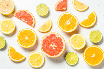 Citrus fruits at white background. Orange, lemon, lime, grapefruit slices. Flat lay.