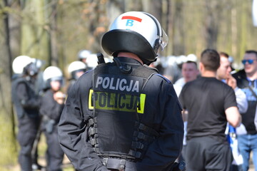 Policjanci prewencji na zabezpieczeniu w stroju ochronnym. 
