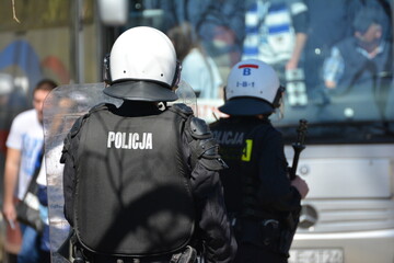 Policjanci prewencji na zabezpieczeniu w stroju ochronnym. 
