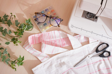 eco shopping bag made of cotton fabric, sewing machine, scissors, glasses and spools of thread on the table, copy space