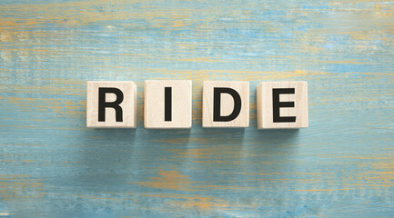 Ride text made of wooden cube on wooden background.