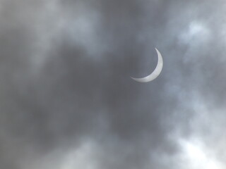 Obraz na płótnie Canvas Luna brillando en un cielo oscuro - cielo negro oscuro por la noche - nubes que cubren la luna - eclipse - media luna