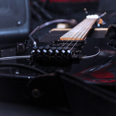 Black electric guitar with tremolo on a hard case