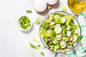 Green salad with fresh leaves, radish, cucumber and ollive oil. Spring healthy dish, vitamin-rich salad.