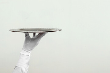 The waiter's hand in white gloves holds a silver tray. Isolate on a light background.