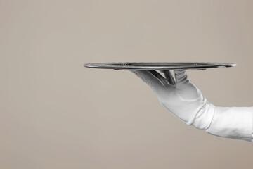 The waiter's hand in white gloves holds a silver tray. Isolate on a light background.