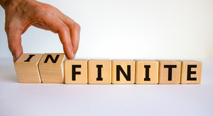 Finite or infinite symbol. Businessman turns wooden cubes and changes the word 'finite' to...