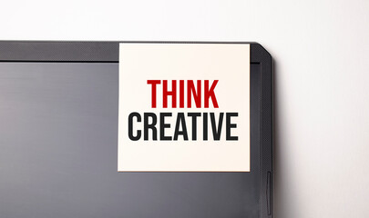 Sticky note on the computer. Text Think Creative