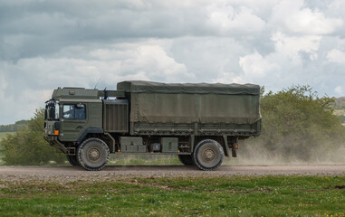 British army MAN SV 4x4 army lorry logistics vehicle truck driving along a dirt track on maneuvers, Salisbury Plain Wiltshire