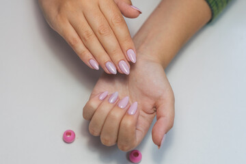 Manicure on a white background. Female hands with long nails. Girl's hands with a gentle pink manicure on a white background.