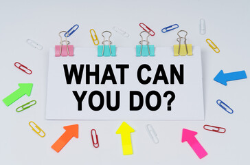 On the table there are paper clips and directional arrows, a sign that says - What Can You Do