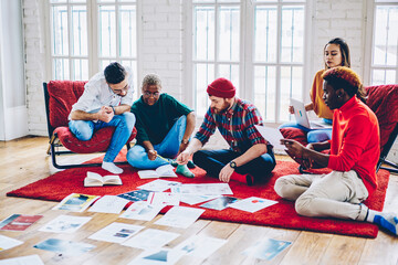 Diverse male and female colleagues cooperate on startup project during freelance meeting for brainstorming, team of creative graphic designers communicate about distance task in stylish flat