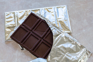 Dark chocolate bar pieces on marble table