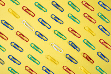 Collection of colorful paper clips isolated on yellow