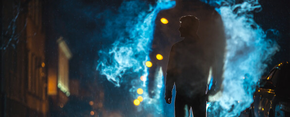 The man stand near the cloud of smoke. Evening night time