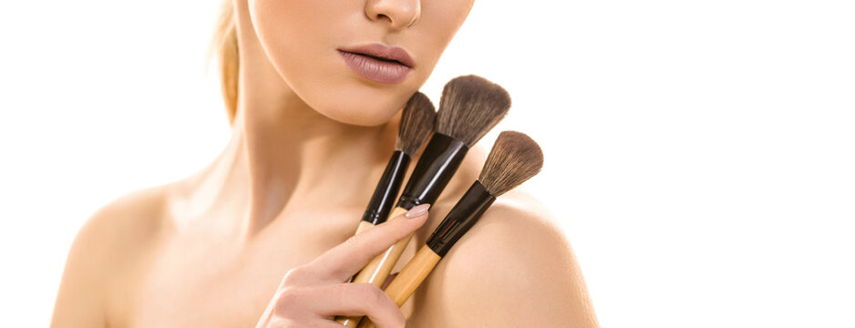 The cute woman with cosmetic brushes on the white background