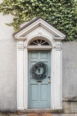 Fototapeta na wymiar Picture perfect robin's egg blue front door with wreath and greenery