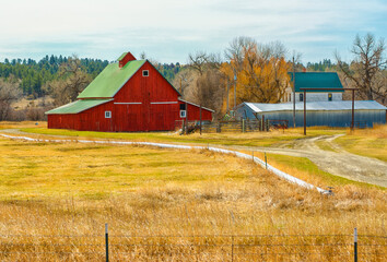 A red barn with a green roof on the Montana landscape