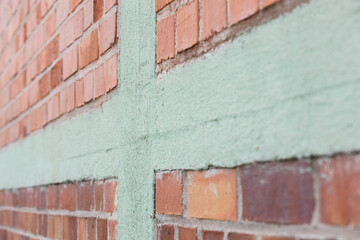 red brick wall with green cement elements, no person