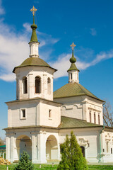 Fototapeta premium An old church.The green dome of the church with a cross on the background of the blue sky. Cross on the dome of the Orthodox church.