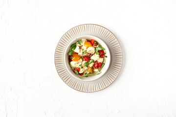 Caprese salad with mozzarella, tomatoes and microgreens in a plate and on a white background.