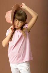 Girl in stylish summer clothes and straw hat