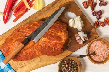 Meat, Pork neck in marinade and on a chopping boardon. Raw steak meat pork neck on chopping board with chili. Raw meat for grilling. White background.