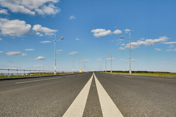 A road with road marking goes into the distance and disappears into the horizon, travel concept