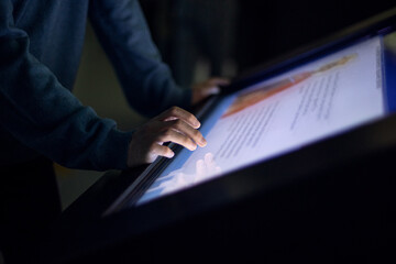 digital touch screen and hands close up, finger on large touch screen.  Interactive screens for...