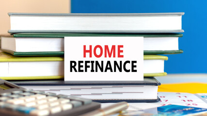 white card with the text home refinance stands against the background of books stacked blue background, defocus