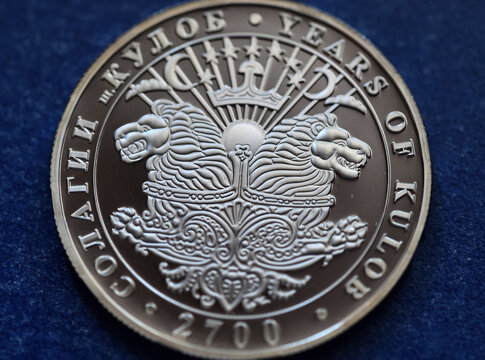 a silver coin from tajikistan with a shield with two lions
