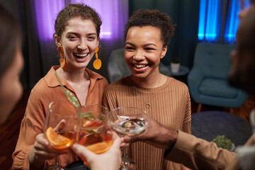 High angle angle view at multi-ethnic group of friends clinking glasses while enjoying party indoors