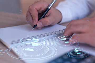 Hands writing down some ideas to create innovative software to change the world and provide a completely new service. Close up shot. Hologram tech graphs. Concept of Dev team. Formal wear.