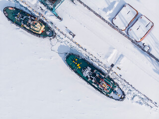 Ice bound ships froze in snow in winter, waiting for breaker, aerial top view