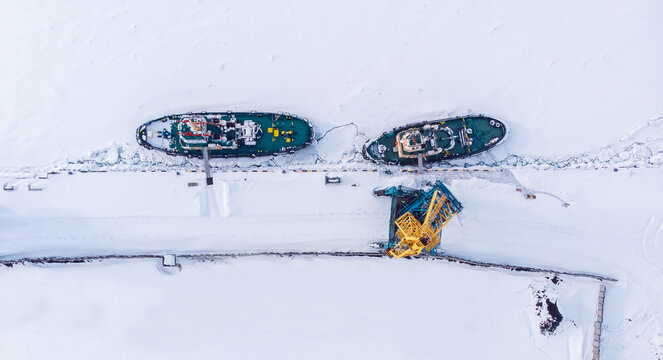 Ice bound ships froze in snow in winter, waiting for breaker, aerial top view