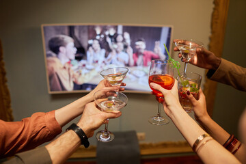 Close up of unrecognizable people clinking glasses to screen while celebrating online with friends