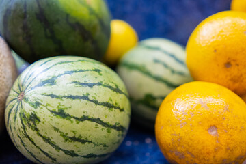 Close-up of colorful fruit stand with watermelons and a oranges