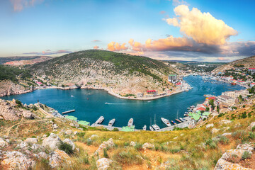 Panoramic view of Balaklava bay with yachts and ruines of Genoese fortress Chembalo in Sevastopol city from the height.